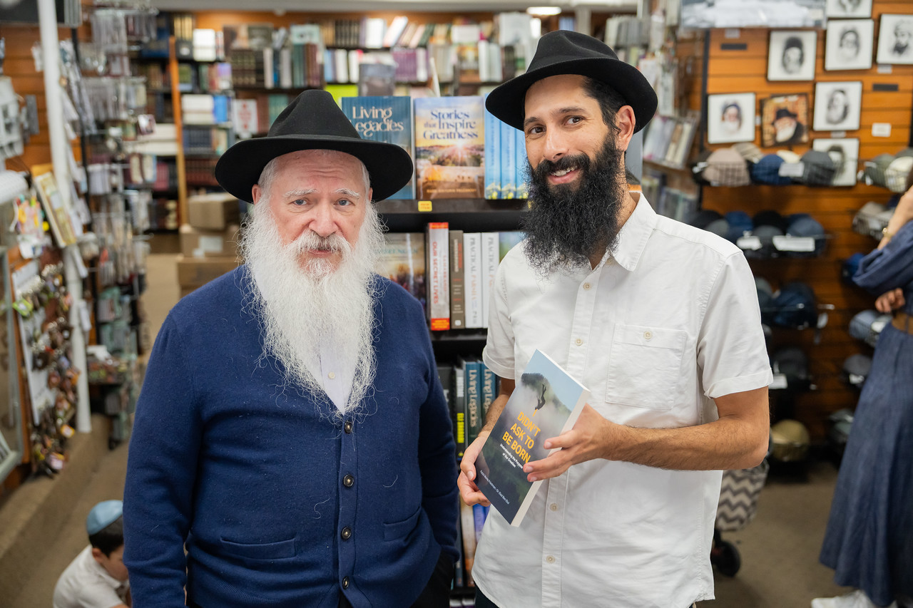 Dr. Yehuda Elad Ben Elul holding his book, I Didn't Ask to Be Born